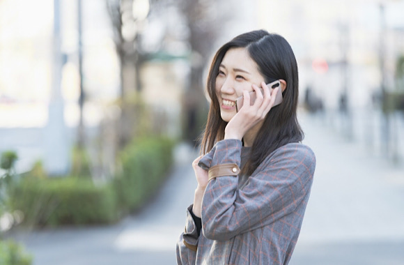 スマートフォンで笑顔で電話する女性
